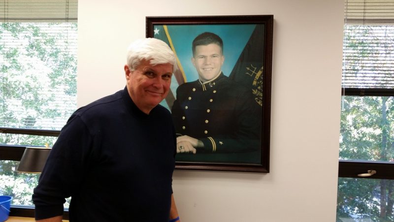 Bill Elliott stands in front of the Naval Academy portrait of his son that serves as the iconic image of the John R. Elliott HERO Campaign for Designated Drivers.